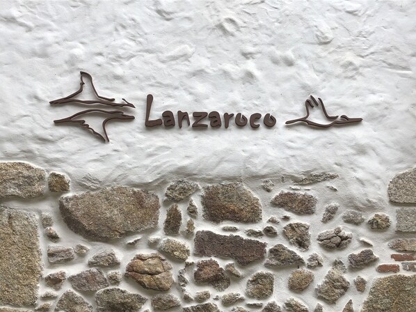 Un mur à la texture de pierre, sur lequel est gravé en métal le nom « Lanzarote ».