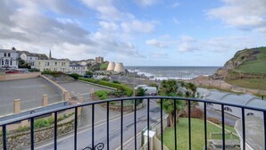 Une ville côtière offrant une vue sur la mer, les bâtiments et un espace de stationnement.