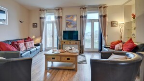 Un salon comprenant un canapé, une table basse et un téléviseur.