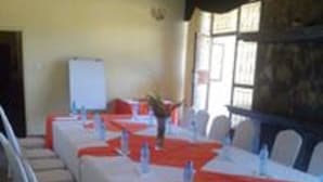 A conference room with a long table, white chairs, and orange tablecloths.