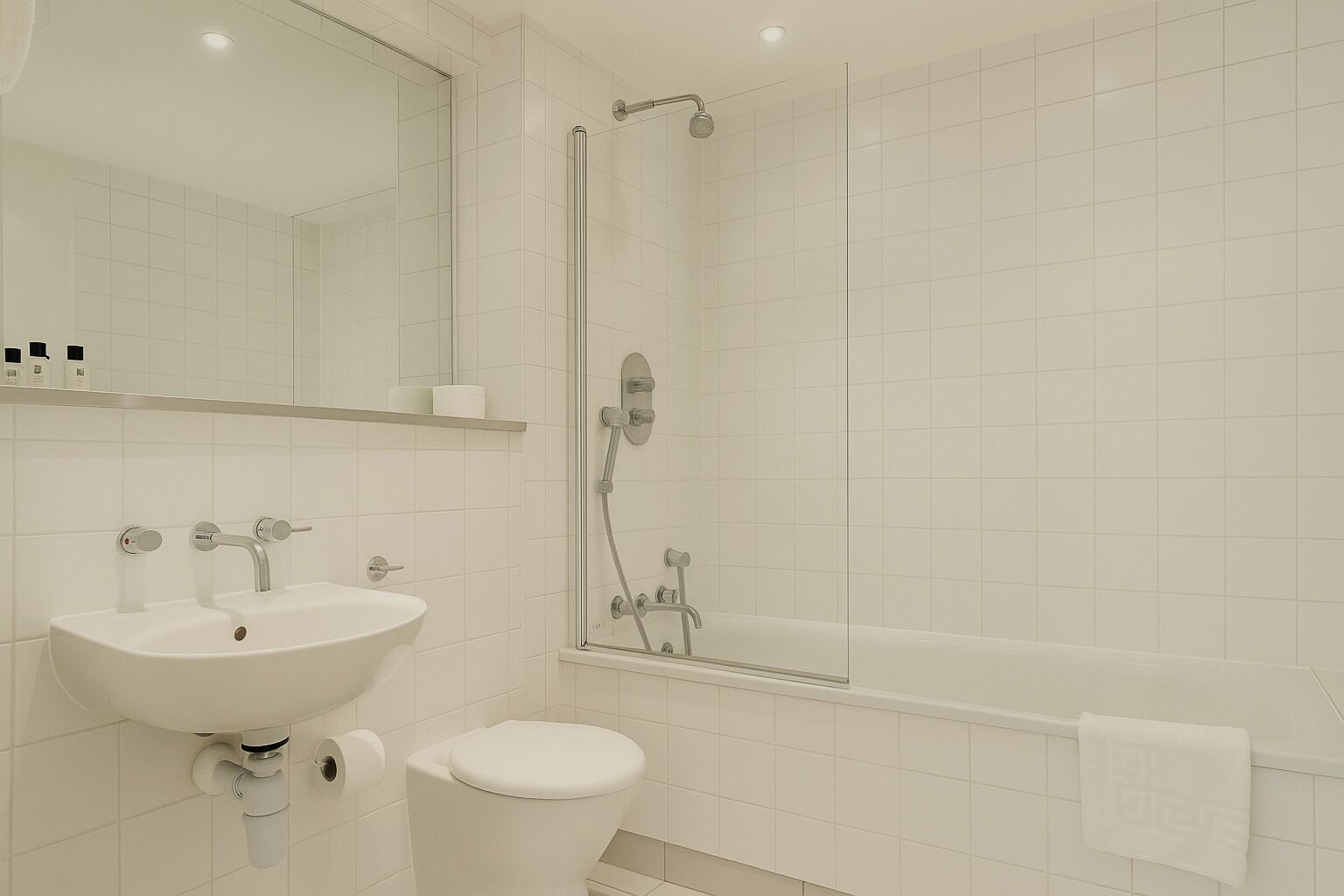 A modern bathroom with a sink, toilet, and shower.