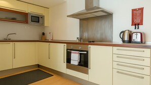 A compact kitchen with a microwave, oven, and toaster. - Still Life Old Street (London)