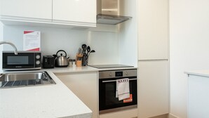 A modern kitchen with a microwave, toaster, kettle, and oven. - Still Life Chancery Lane (London)