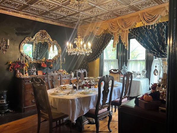 A dining room with ornate ceiling, chandeliers, and a large mirror. - Walk to Everything -Blue Room (Niagara Falls)