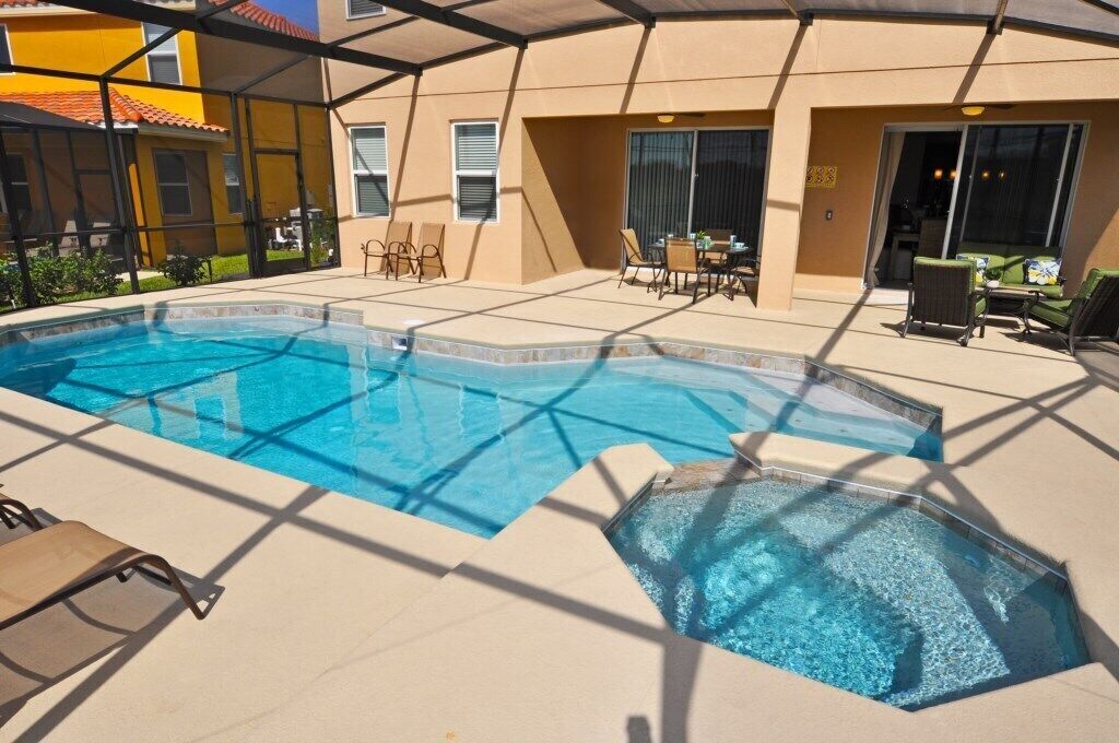 En swimmingpool med liggestole og en overdækket patio.