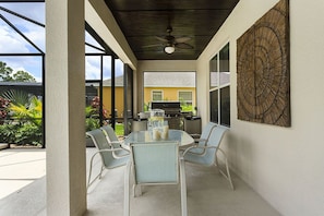 Relax in style with a round table and comfortable seating, surrounded by lush greenery and a view of the surrounding area.