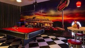 Uma mesa de bilhar com um letreiro de neon ao fundo e um chão xadrez.