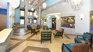 A spacious lobby with a high ceiling, wooden beams, and a central seating area with colorful chairs. - 4 Bedroom 3 Bathroom Townhome w Pool (Davenport)