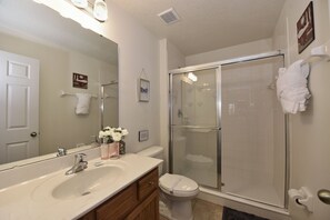 Ein Badezimmer mit großem Spiegel, Waschbecken, Toilette und einer Duschkabine.