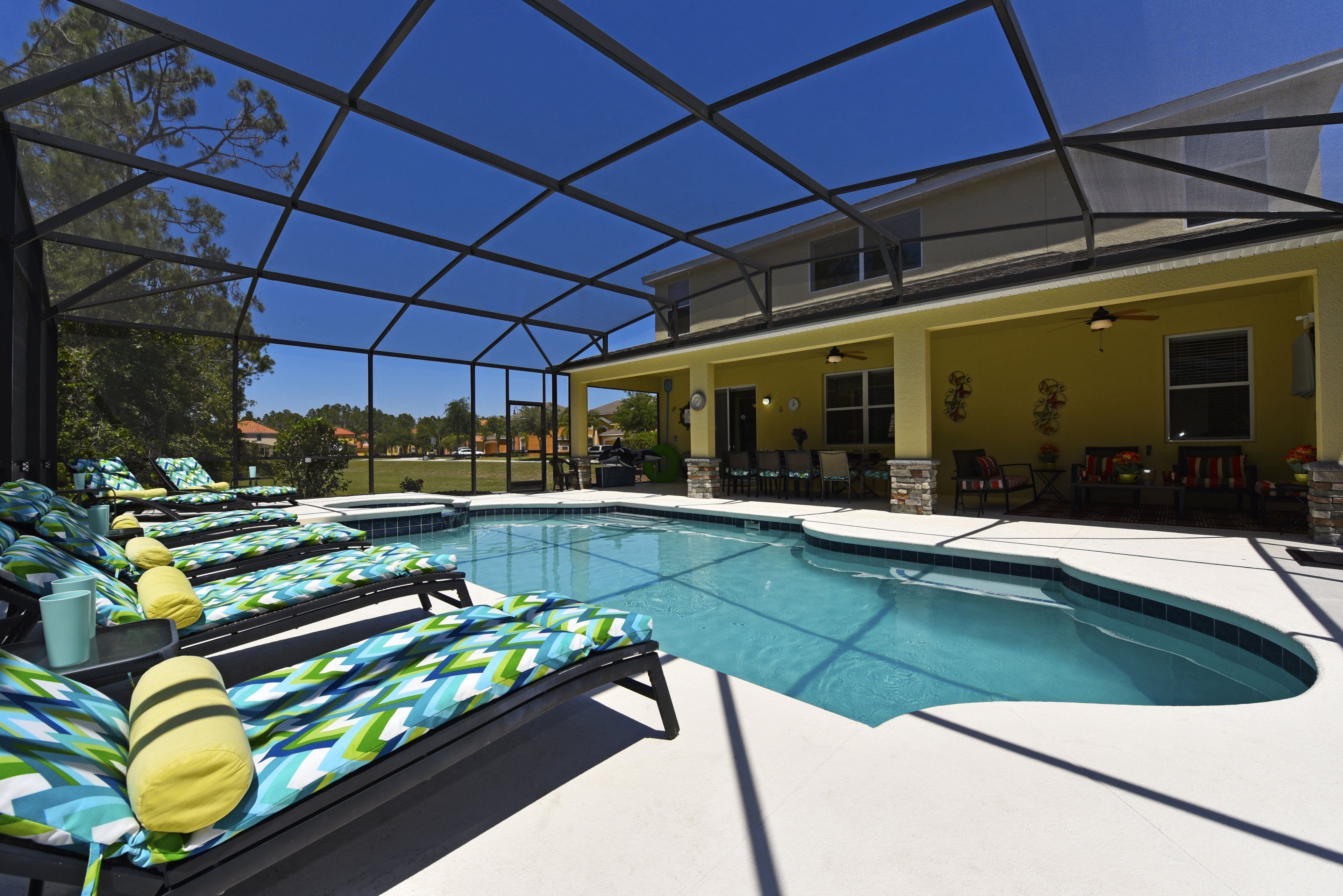 A pool area with lounge chairs and a covered patio.