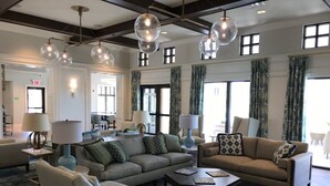 A spacious living room with a large sofa, armchairs, and a coffee table. There are multiple lamps and a chandelier. The room has large windows with curtains and a view of the outside. - Summer Specia 4 BRM W Pool (Kissimmee)
