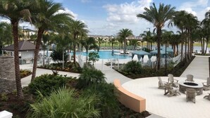 A resort pool area with palm trees, lounge chairs, and a clear view of the pool. - Summer Specia 4 BRM W Pool (Kissimmee)