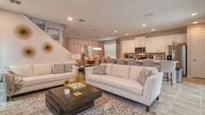 A spacious living room with a large sectional sofa, a dark wood coffee table, and a patterned rug. - Summer Specia 4 BRM W Pool (Kissimmee)