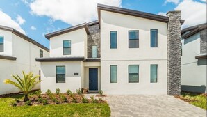 Un immeuble résidentiel moderne à plusieurs étages, doté d’un toit plat, de grandes fenêtres et d’un mur d’accent en pierre.