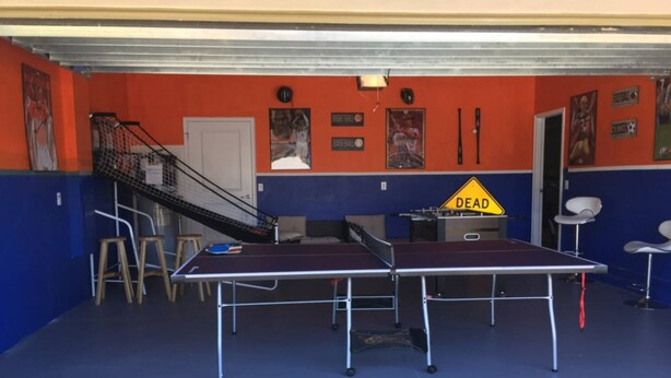 A ping pong table in a room with blue and orange walls, a staircase, and a 'DEAD' sign on the wall. - Champions Gate IHR 4014 (Davenport)