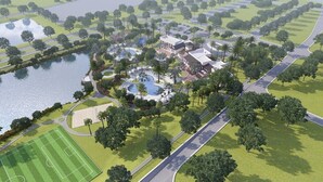 An aerial view of a resort with a central building, a swimming pool, and a tennis court.