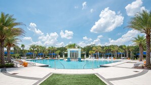 Ein Poolbereich mit Liegestühlen, Palmen und einer Wasserspielplatz.