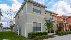 A two-story residential building with a flat roof, large windows, and a small front yard with a tree and shrubs. - Paradise Palms IHR 2007 (Kissimmee)