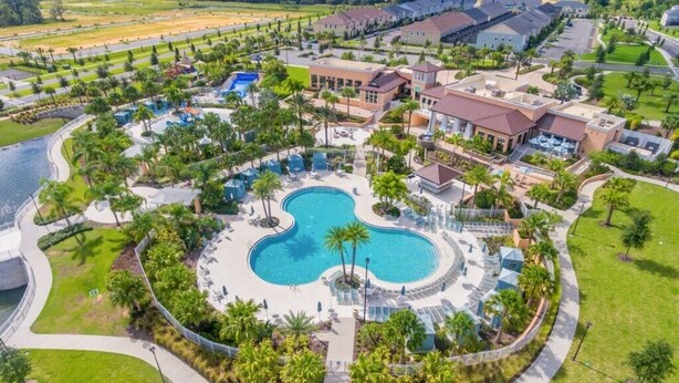An aerial view of a resort with a central swimming pool, surrounded by palm trees and lounge areas. - Summer Special Solara Villa (Kissimmee)