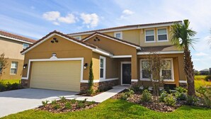 A single-story house with a beige garage door, a small front porch, and a well-maintained lawn with a palm tree. - Solterra Resort IHR 3049 (Davenport)