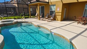 A swimming pool with a sunshade area, lounge chairs, and a patio table. - Solterra Resort IHR 3049 (Davenport)