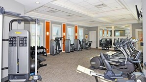 Une salle de sport équipée de machines de cardio, de machines de musculation et de poids libres.