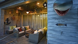 A cozy, nautical-themed lounge area with wicker furniture, a large anchor decoration, and a sign stating "Fish are Friends Not Food." - Festival Resort IHR 3023 (Davenport)