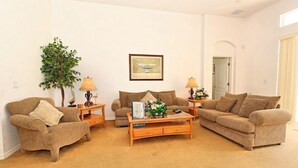 Uma sala de estar com dois sofás, uma mesa de centro e uma luminária.