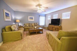 Villa | Woonkamer | Een flatscreentelevisie, een open haard, een dvd-speler en tafelvoetbal