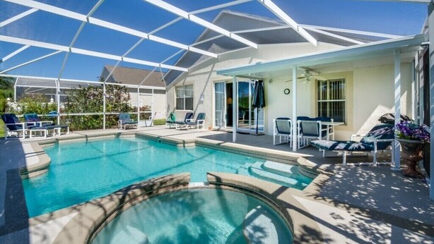 A covered outdoor swimming pool with lounge chairs and a patio area. - 1802nhd (Davenport)