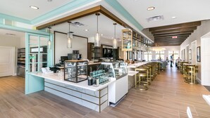 A modern kitchen with a central island, pendant lighting, and a view of the dining area. - Amazing 6 Bedroom 5 Bathroom Solara Resort Villa (Kissimmee)