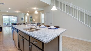 A modern kitchen with granite countertops, stainless steel appliances, and pendant lighting. - 1631la Luxury 6 Bed Villa With Pool & Spa (Kissimmee)