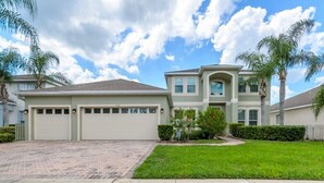 A two-story house with a garage, a driveway, and a well-maintained lawn. - 337 Belfry (Davenport)