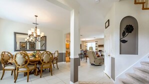 A spacious dining area with a chandelier, a dining table with chairs, and a staircase leading to another level. - 337 Belfry (Davenport)