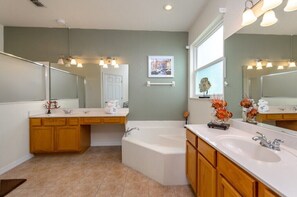 A bathroom with a double sink, a bathtub, and a large mirror. - 337 Belfry (Davenport)