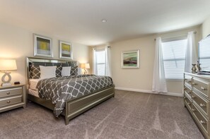 A bedroom with a bed, nightstands, a dresser, and artwork on the walls. - 6 Bedroom Golf Course Resort Villa (Davenport)