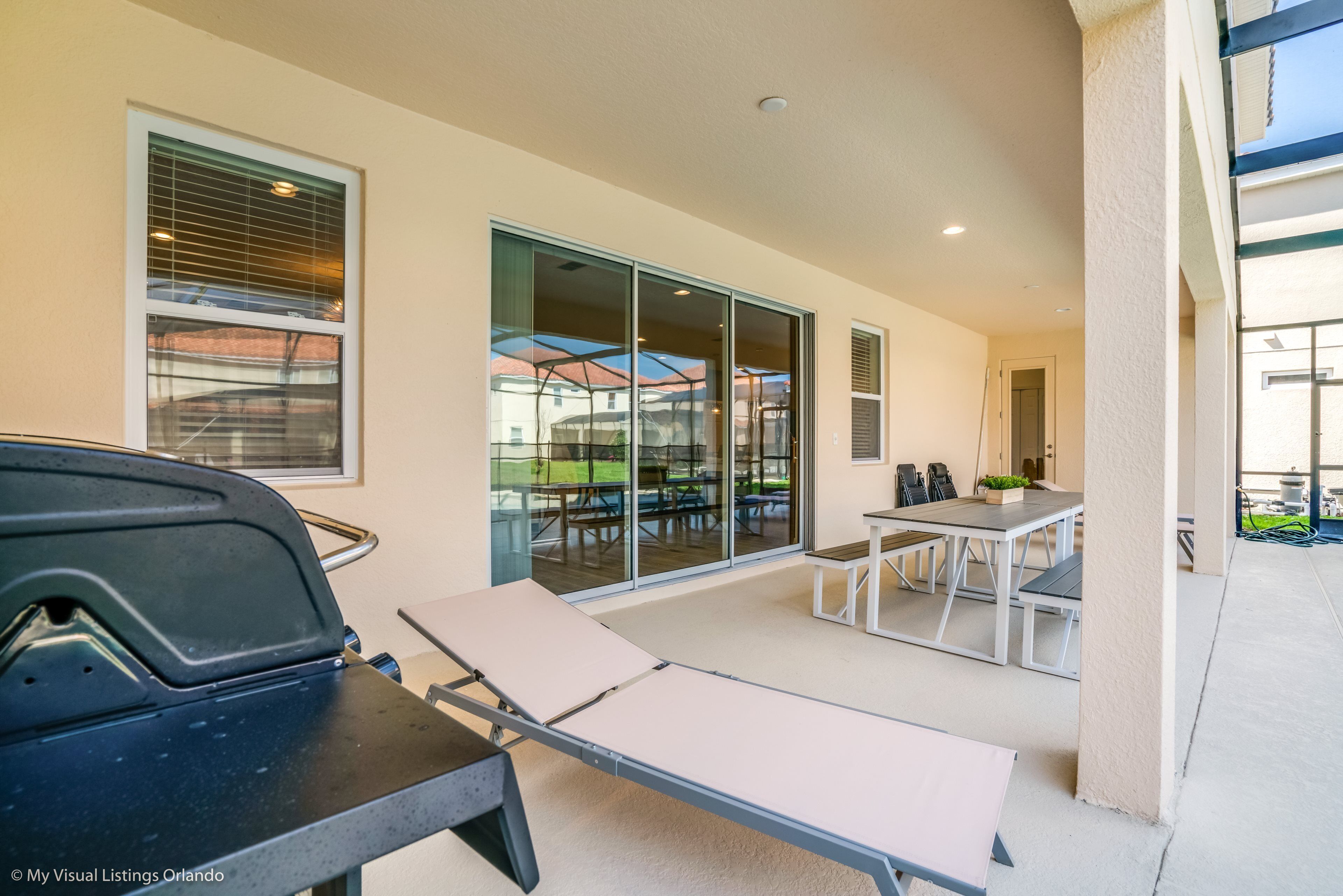 Eine Terrassenausstattung mit Grill, Liegestühlen und Esstisch.
