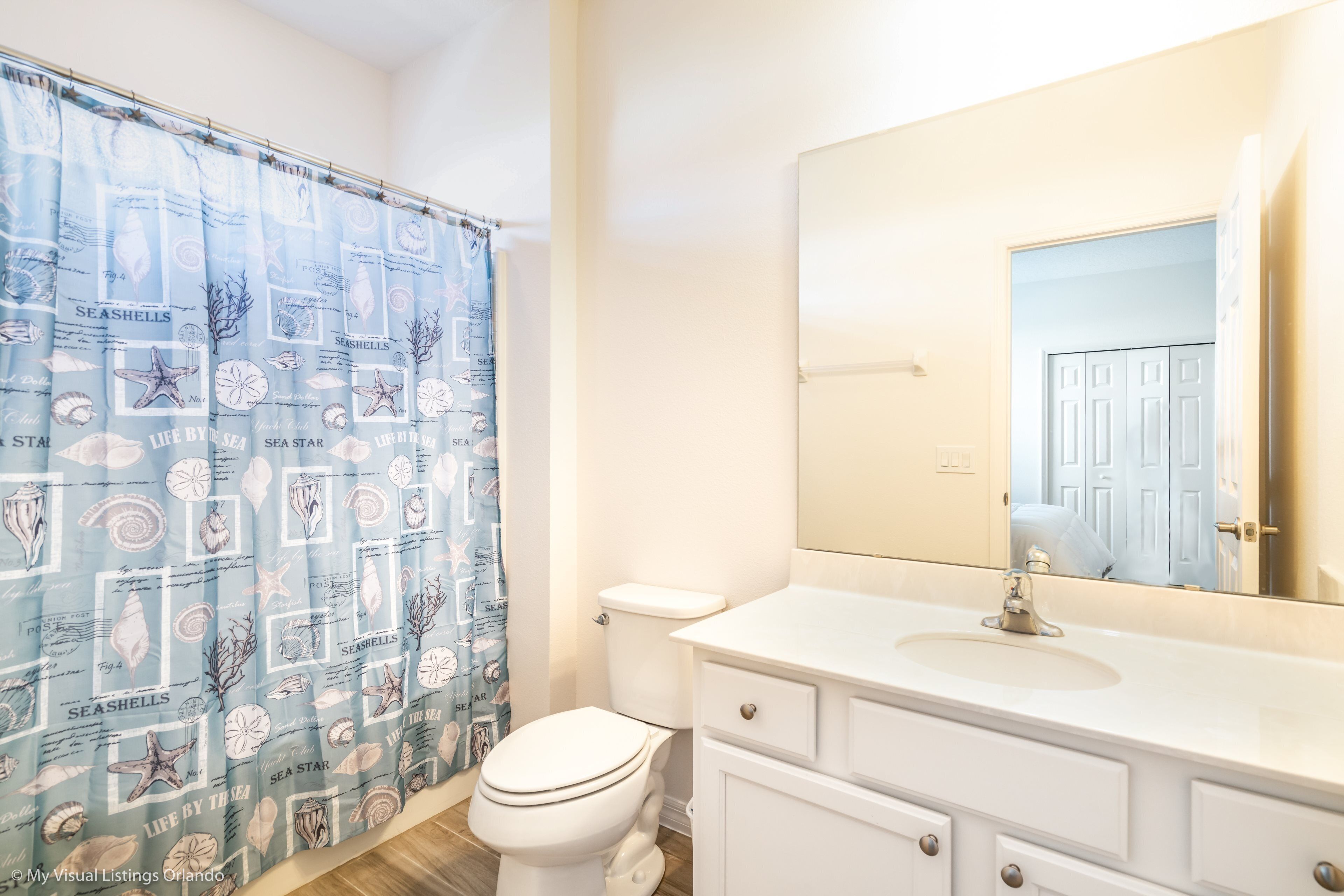 A bathroom with a white toilet, a white sink, and a mirror above the sink.