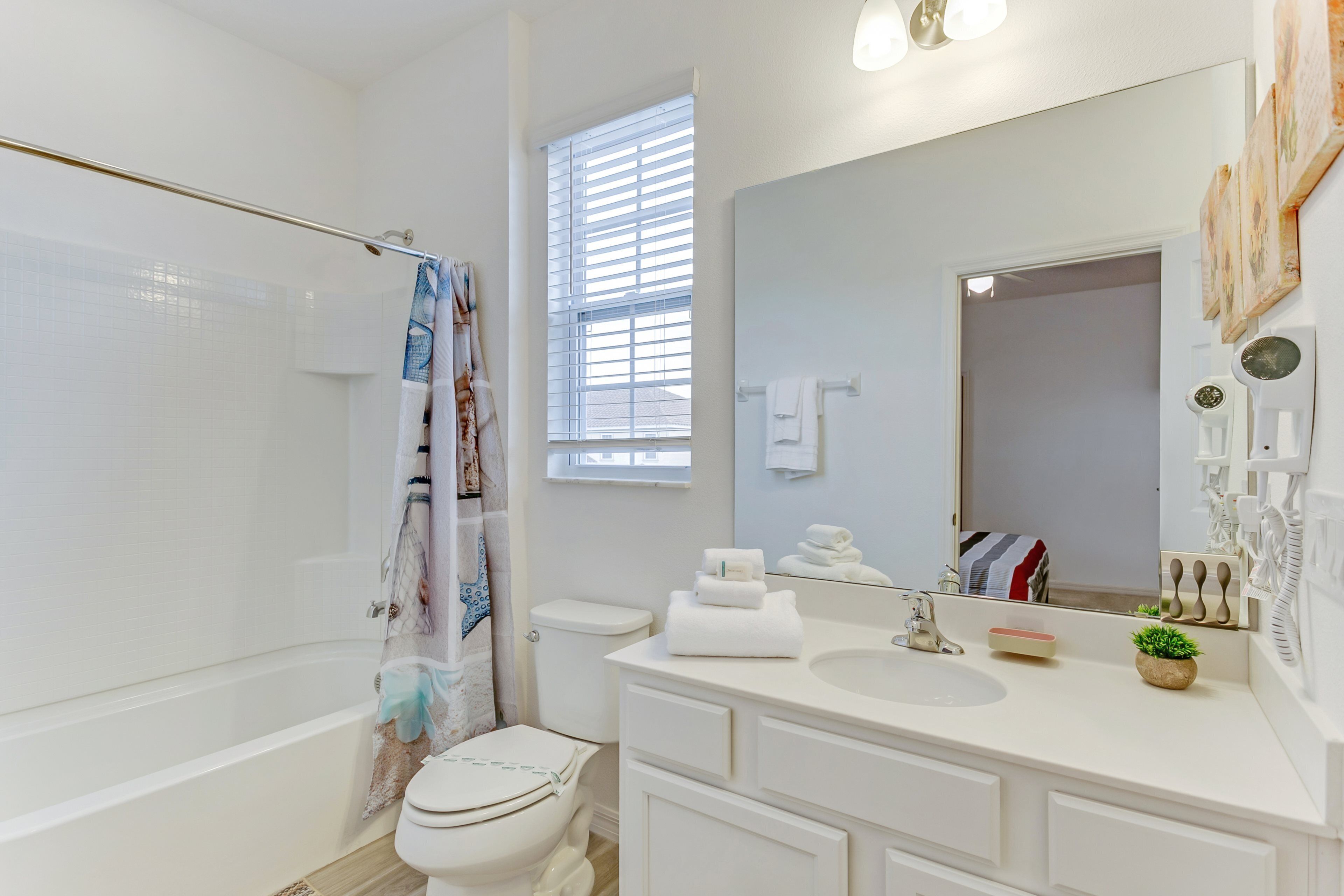 A modern bathroom with a bathtub, toilet, and sink.