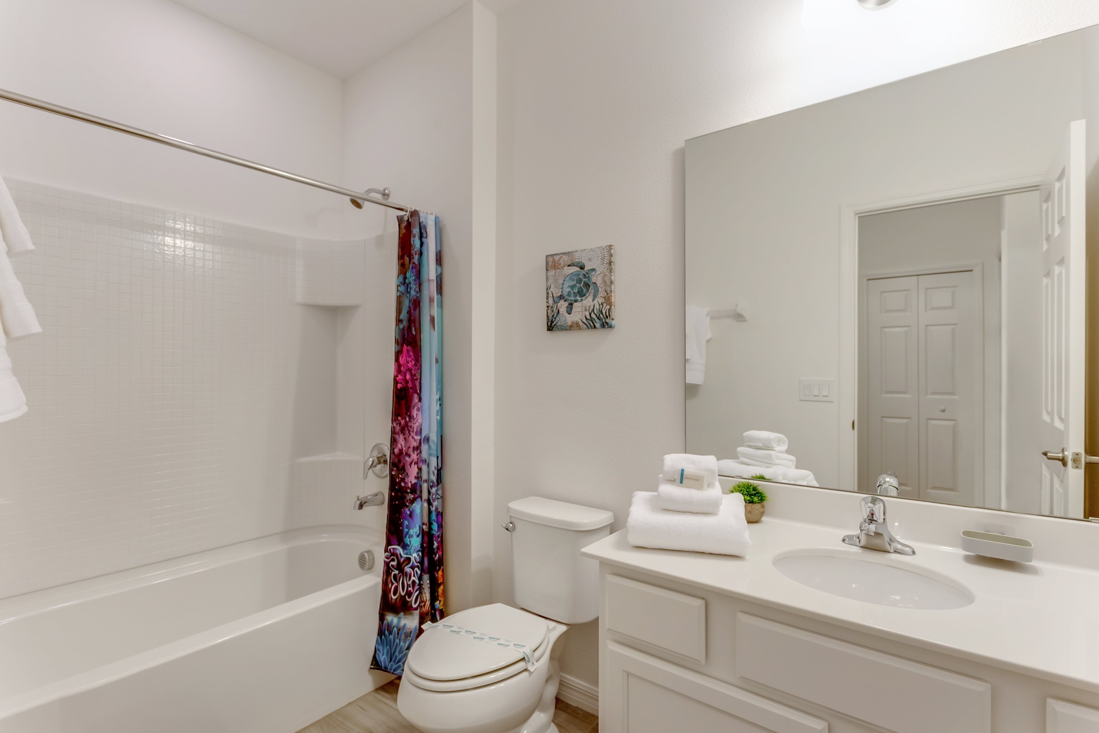 A modern bathroom with a bathtub, toilet, and sink.