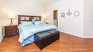 A bedroom with a bed, nightstands, a ceiling fan, and wall decorations. - 170ed (Davenport)