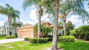 A residential house with a garage, surrounded by well-maintained lawns and palm trees. - 170ed (Davenport)