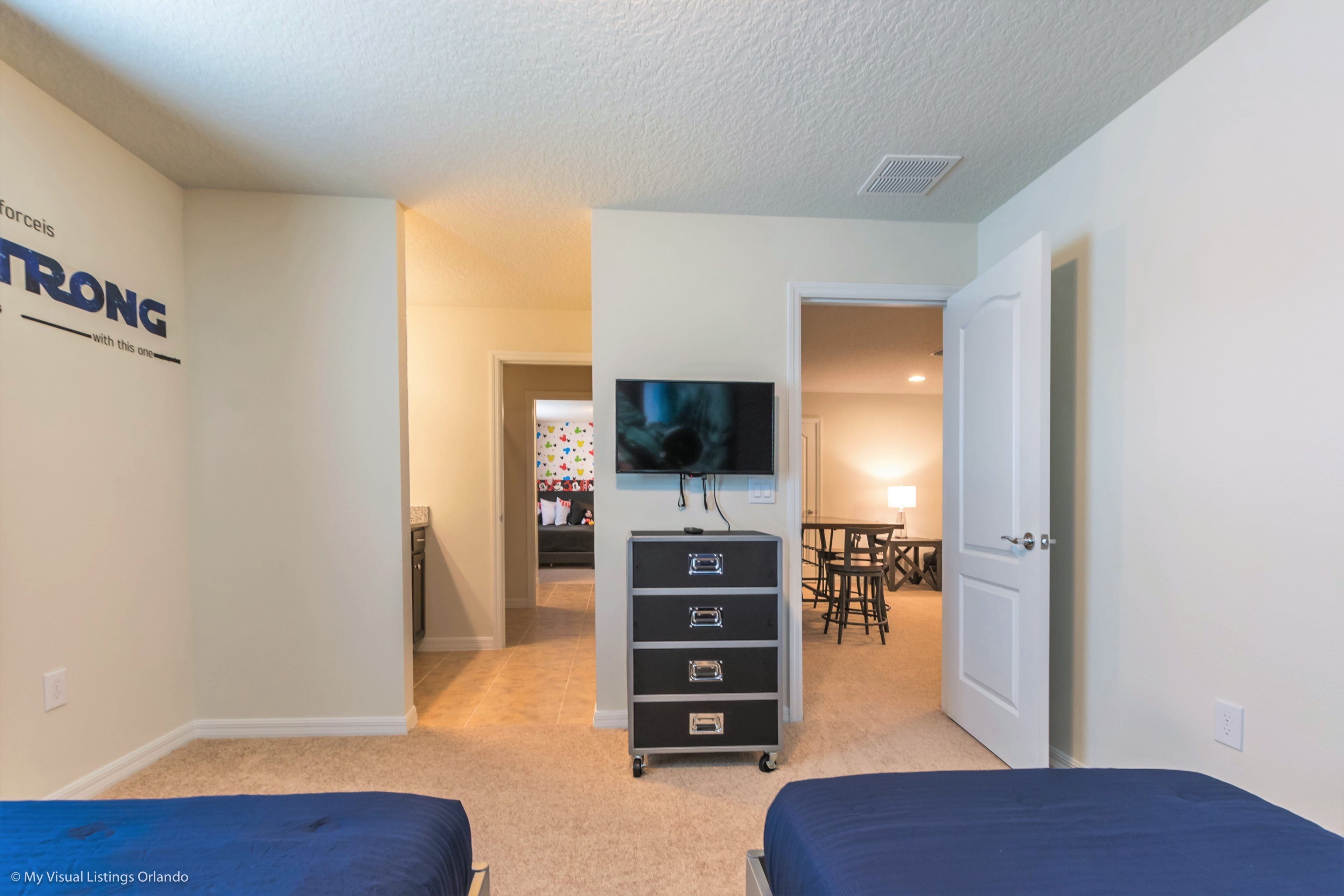 A hotel room with two beds, a TV, a desk, and a chair.