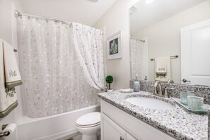 A bathroom with a bathtub, toilet, and sink. - 6 Bed 5 Ba Villa with Pool, Spa & Lake View (Kissimmee)