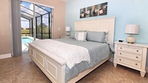 Um quarto com uma cama grande, uma mesa de cabeceira, um abajur e um quadro na parede.