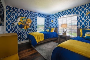 A bedroom with two beds, a dresser, and a window with blinds.