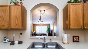 Una cocina con armarios de madera, un lavamanos doble y un lavavajillas.