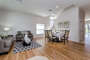 A spacious living room with a dining area, wooden flooring, and a staircase leading to an upper level. - Marbella IHR 4059 (Davenport)