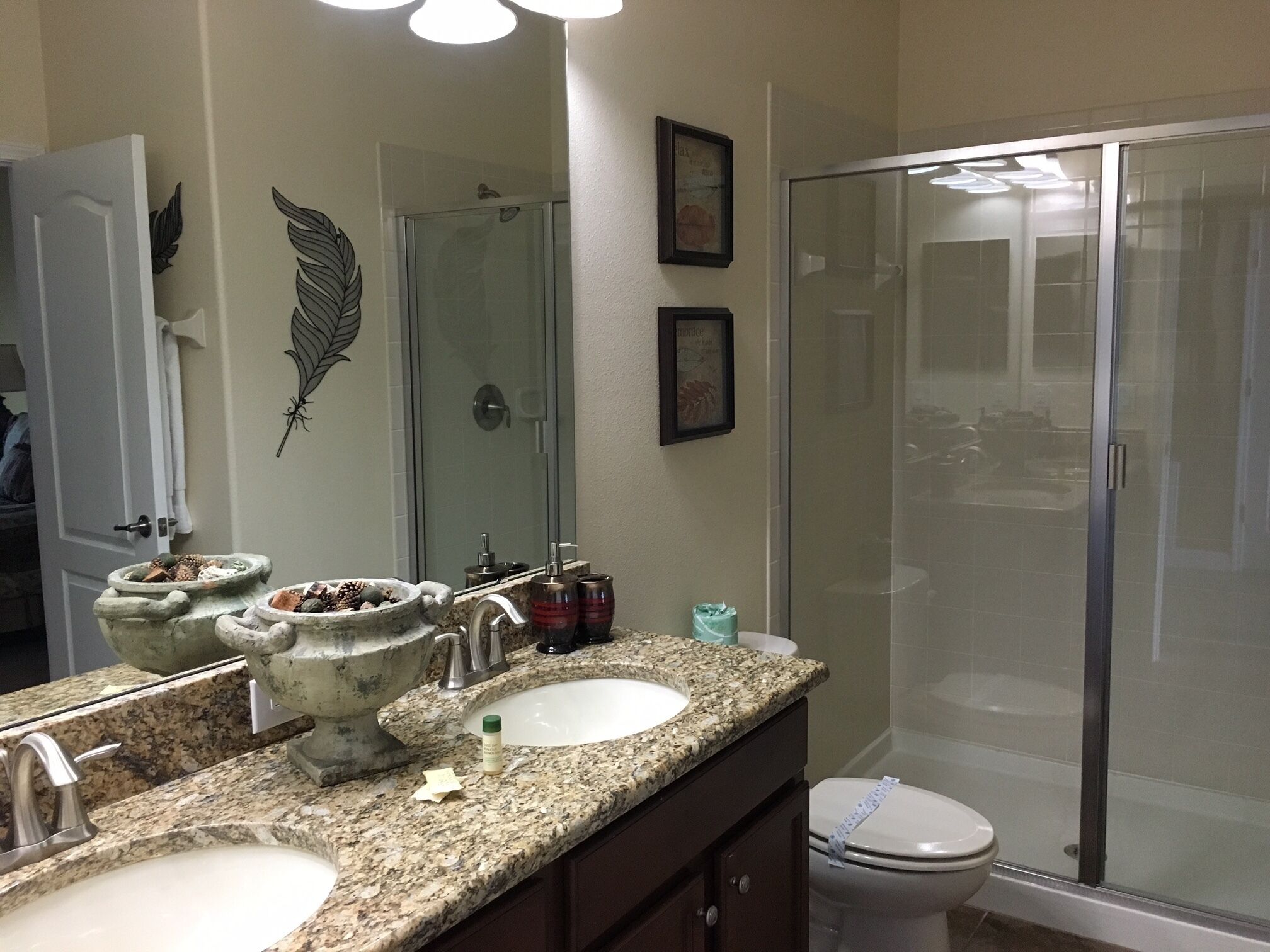 A bathroom with two sinks, a shower, and a toilet.