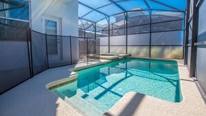 A swimming pool with a glass enclosure, surrounded by a white wall and a door. - 5 Bedroom Resort Villa with Game Room & Pool (Kissimmee)